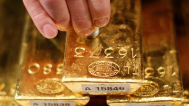 Gold edges lower from near three-week peak on profit-taking